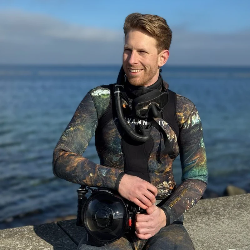 Undervandsfotograf Tim Dencker i dykkerdragt ved havet